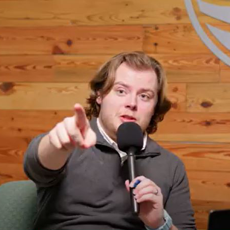 Photo of staff holding a microphone during a podcast episode.